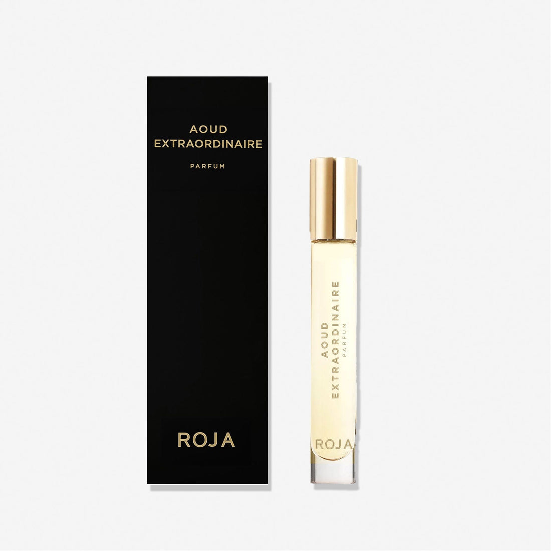 A black and gold box labeled Roja Parfums stands beside a slim, clear Aoud Extraordinaire perfume bottle with a gold cap and text, both highlighting the fragrance’s elegance on a white background.