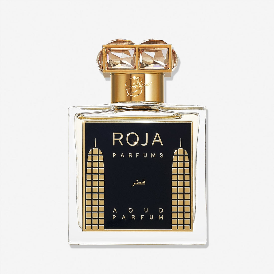 A luxury Roja Parfums Qatar perfume bottle features gold accents, geometric designs, and a crystal-studded gold capâ€”evoking notes of peach and pear in its lavish presentation.