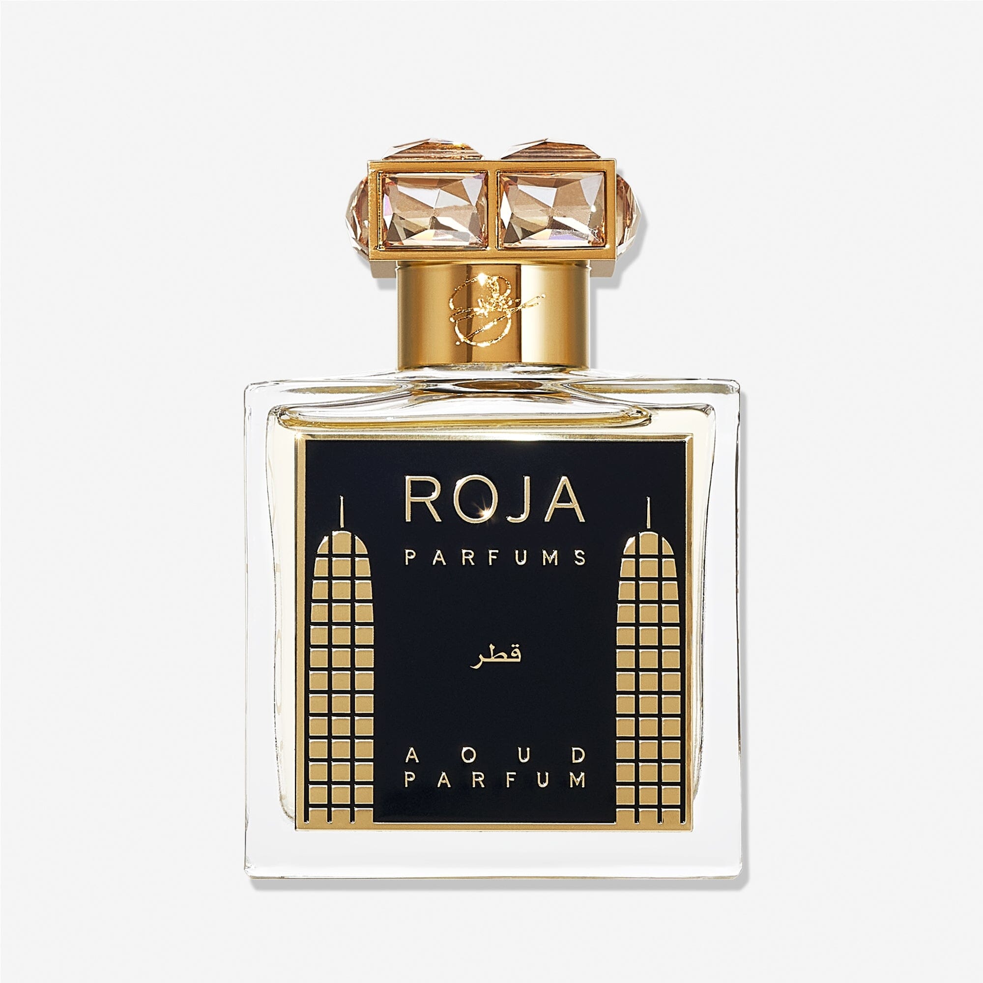 A luxury Roja Parfums Qatar perfume bottle features gold accents, geometric designs, and a crystal-studded gold capâ€”evoking notes of peach and pear in its lavish presentation.