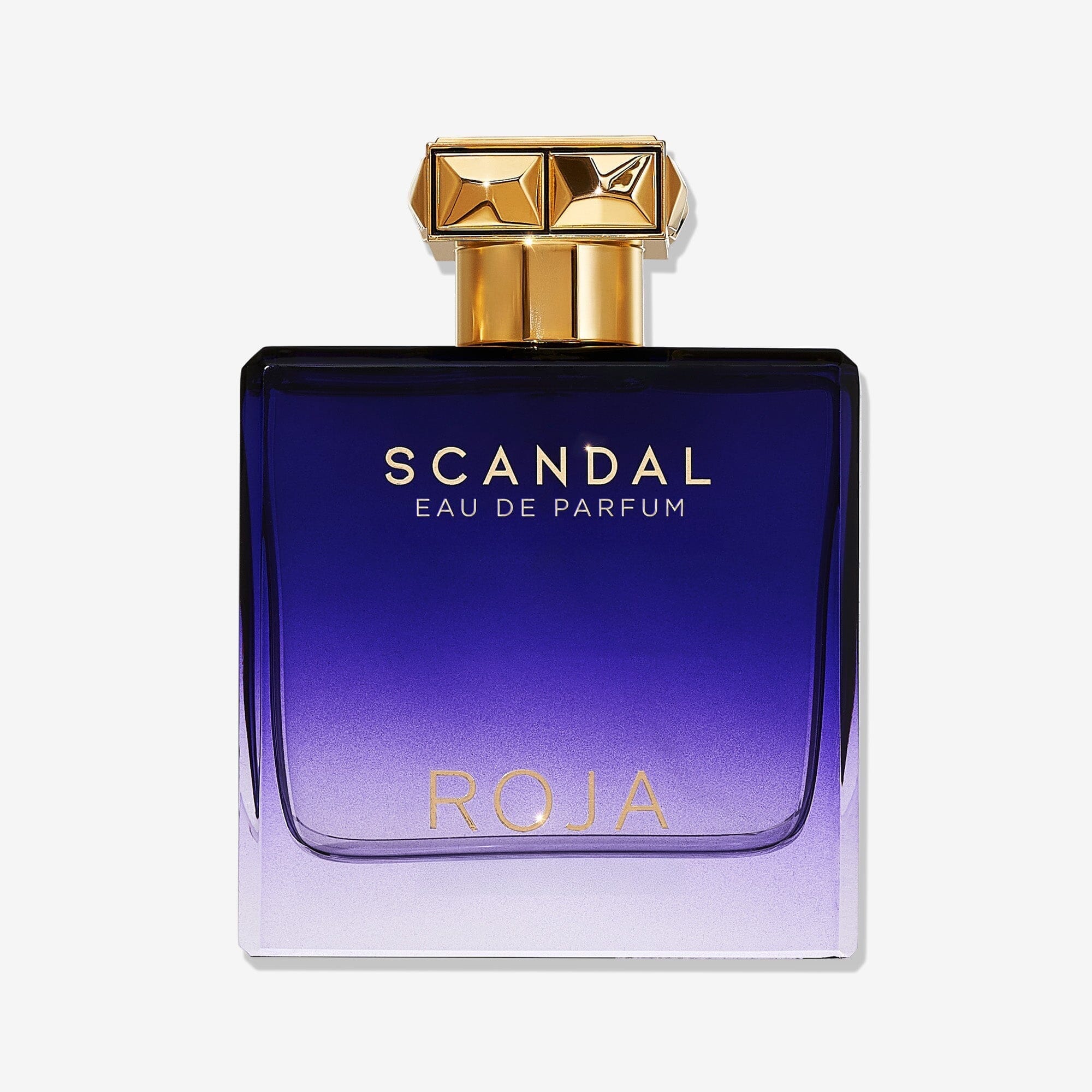 A rectangular perfume bottle with a gold cap and blue-to-purple gradient glass displays "SCANDAL POUR HOMME" in gold and "ROJA PARFUMS" below. This FougÃ¨re scent is for the modern gentleman, shown against a white background.